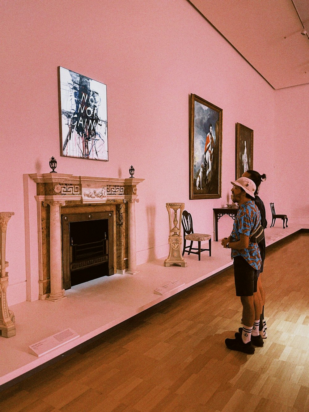 a man standing in front of a fireplace in a pink room