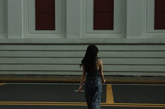 a woman walking across a street in front of a building