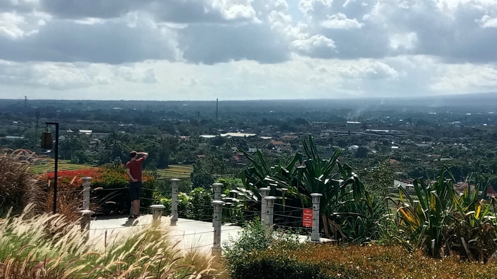 a man standing on top of a lush green hillside