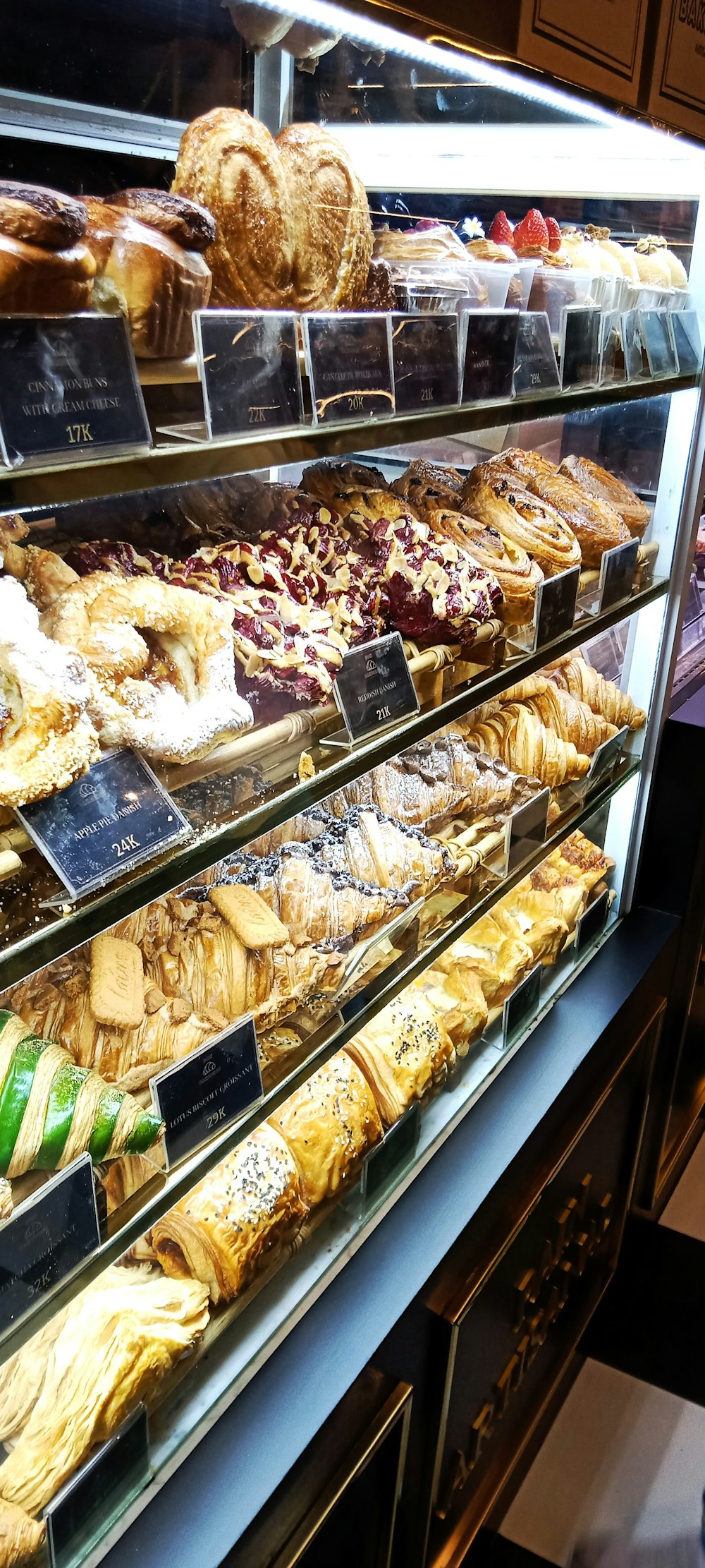 Une vitrine remplie de nombreux types de pâtisseries différentes