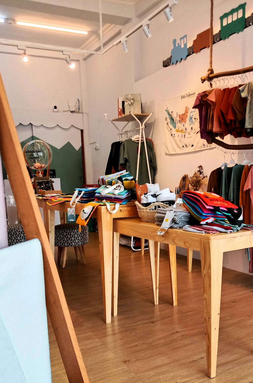 a room with a wooden table and clothes on display