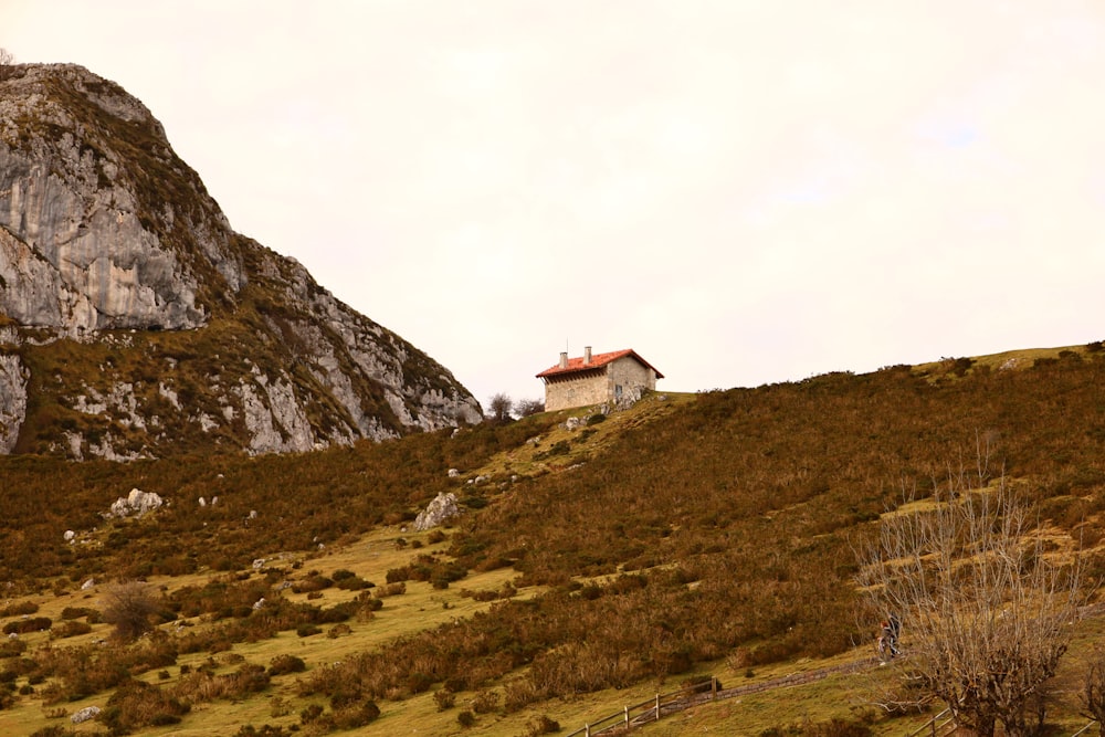 a house on a hill with a mountain in the background