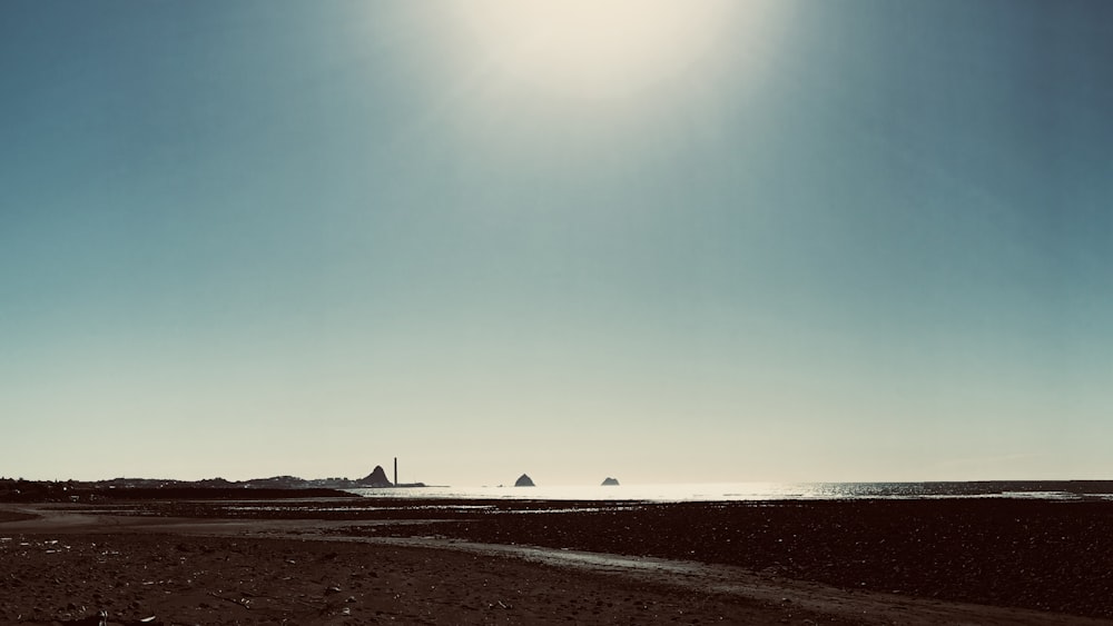 Die Sonne scheint über das Meer und einen Strand