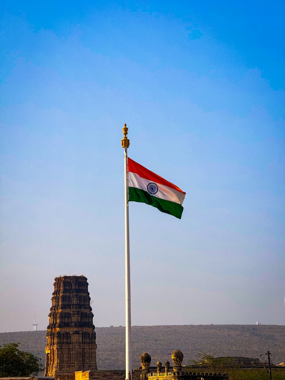 a flag flying in front of a tall tower