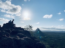 a couple of people sitting on top of a mountain