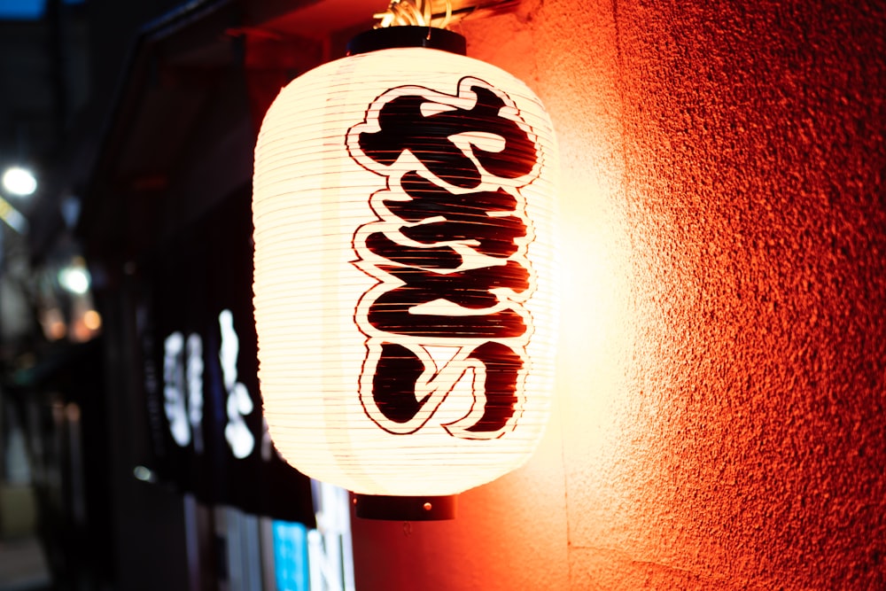 a lit up lantern on the side of a building