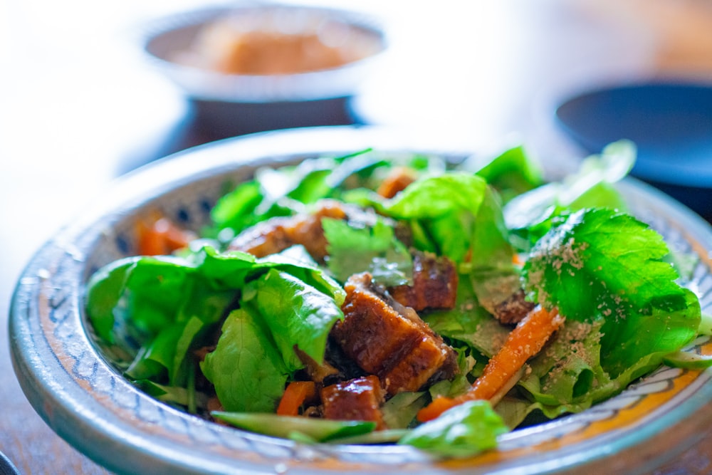 a bowl of lettuce, carrots, and meat