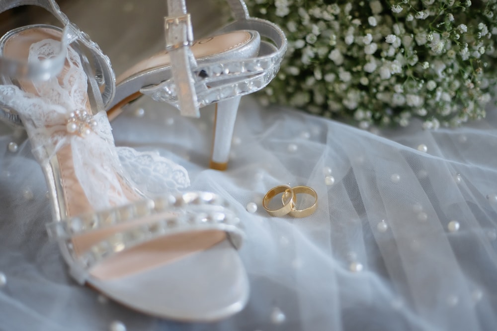 a pair of wedding shoes and a bouquet of flowers