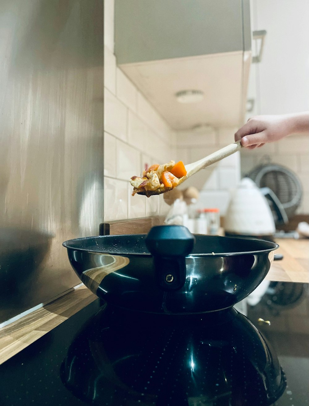 a person spooning food out of a pot on a stove