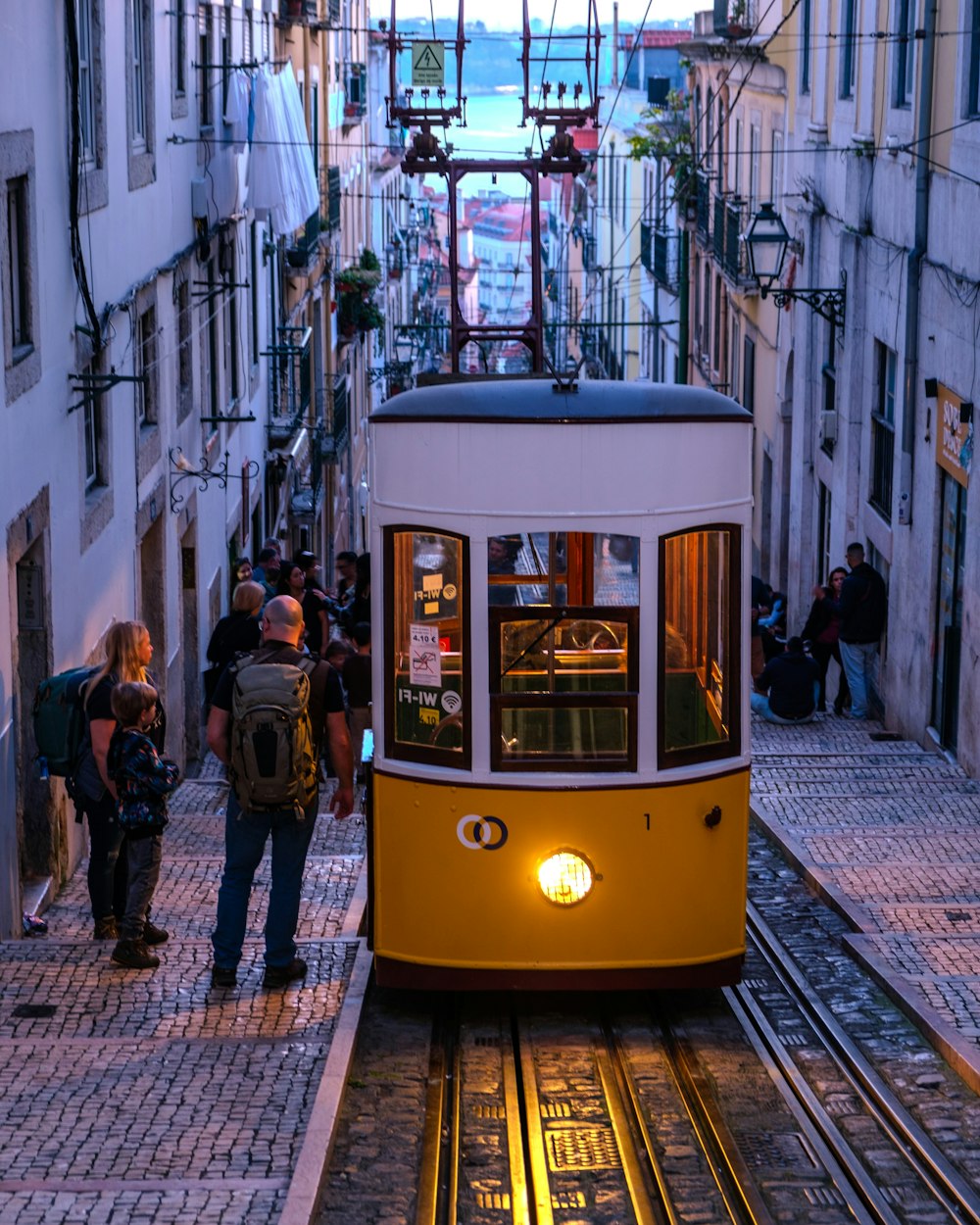 a trolley car is going down a narrow street