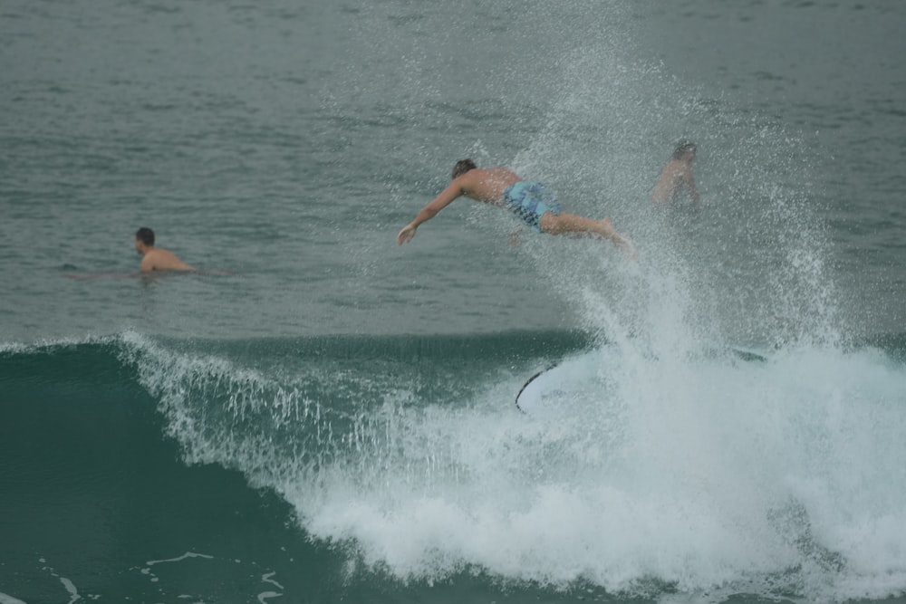 a man falling off of a surfboard while riding a wave