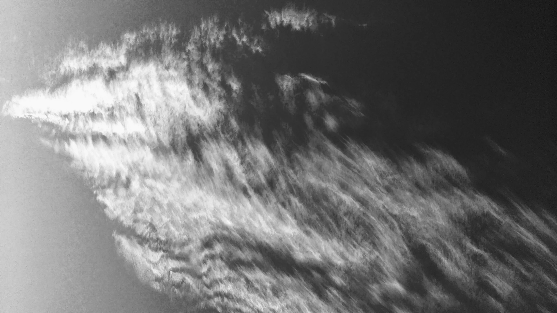a black and white photo of a plane flying in the sky