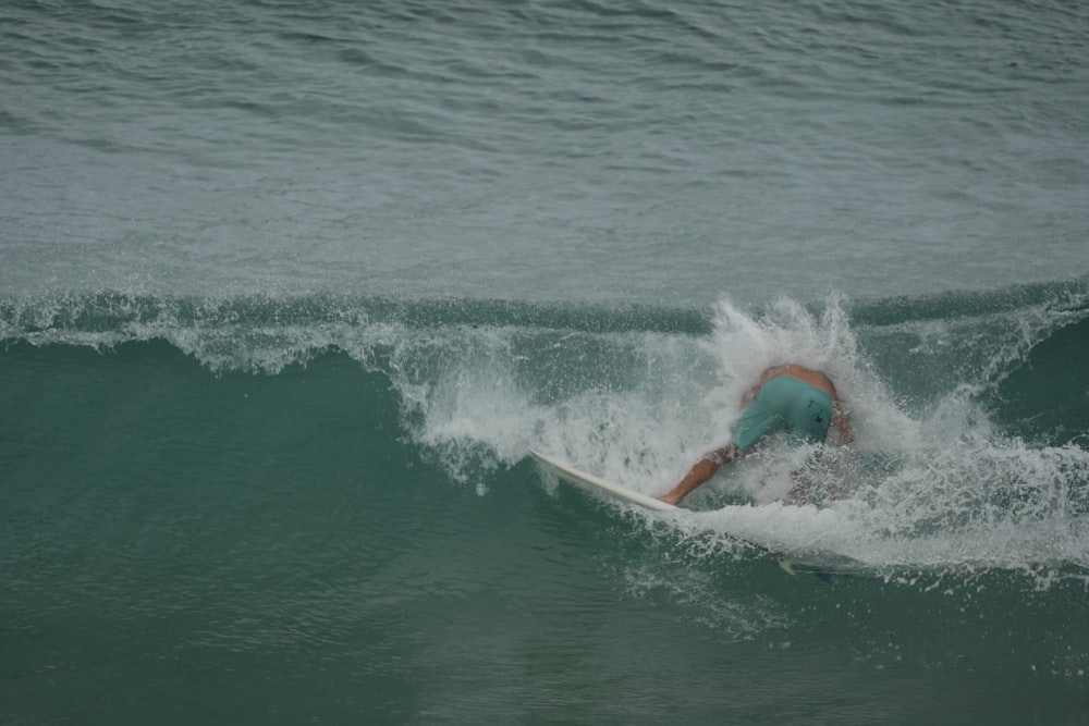 Un hombre montando una ola encima de una tabla de surf