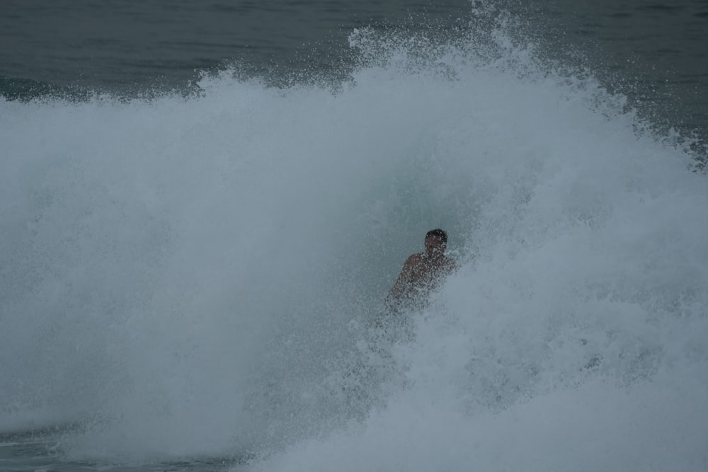 a man riding a wave on top of a surfboard