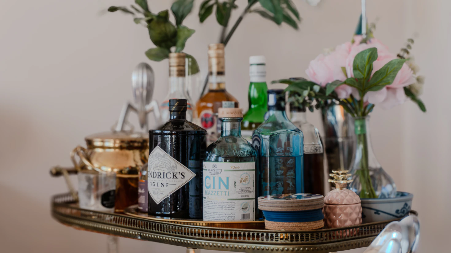 Styled bar cart with bottles, glassware, and flowers ready for entertaining