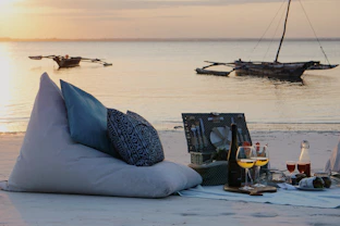 a couple of pillows sitting on top of a sandy beach