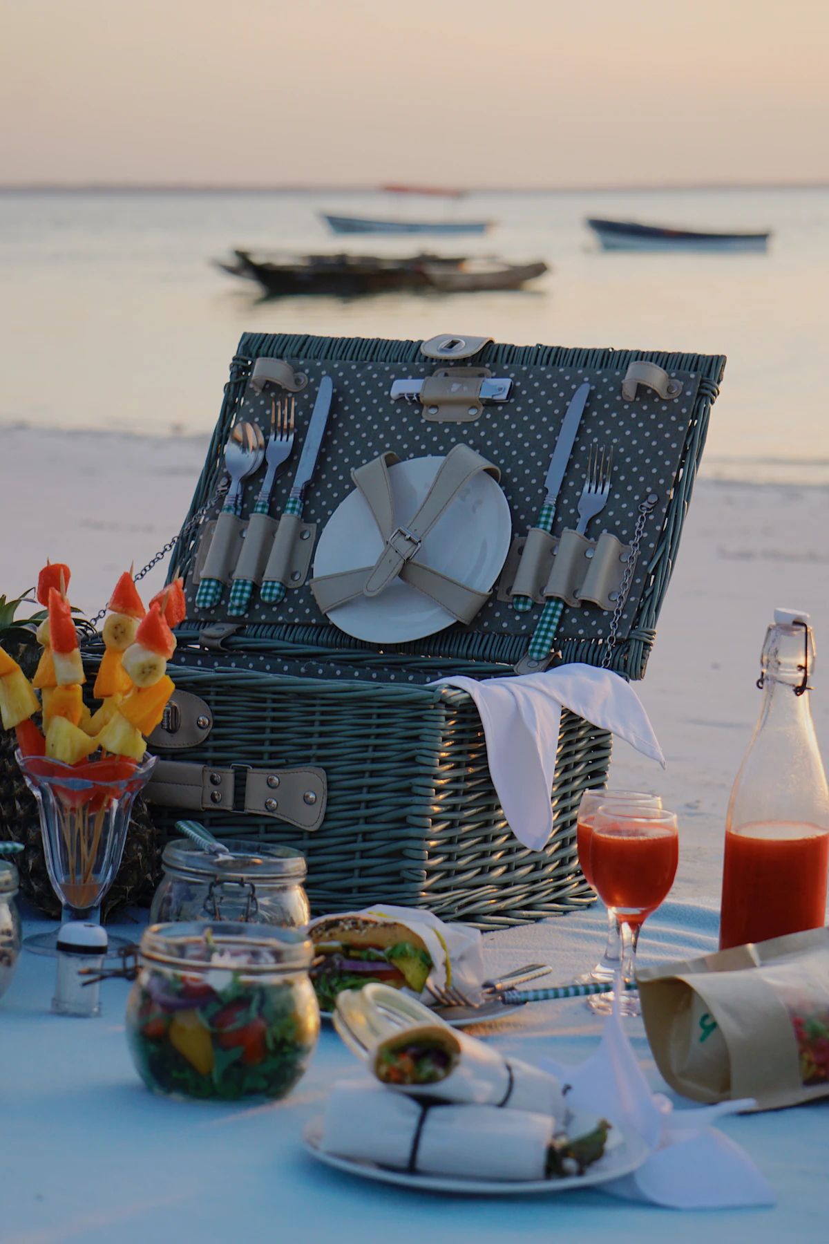 Beach picnic with food and drinks at sunset