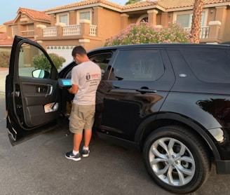 a man opening the door of a black suv