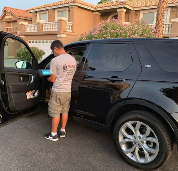 a man opening the door of a black suv