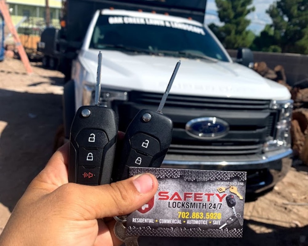 a person holding two remotes in front of a truck