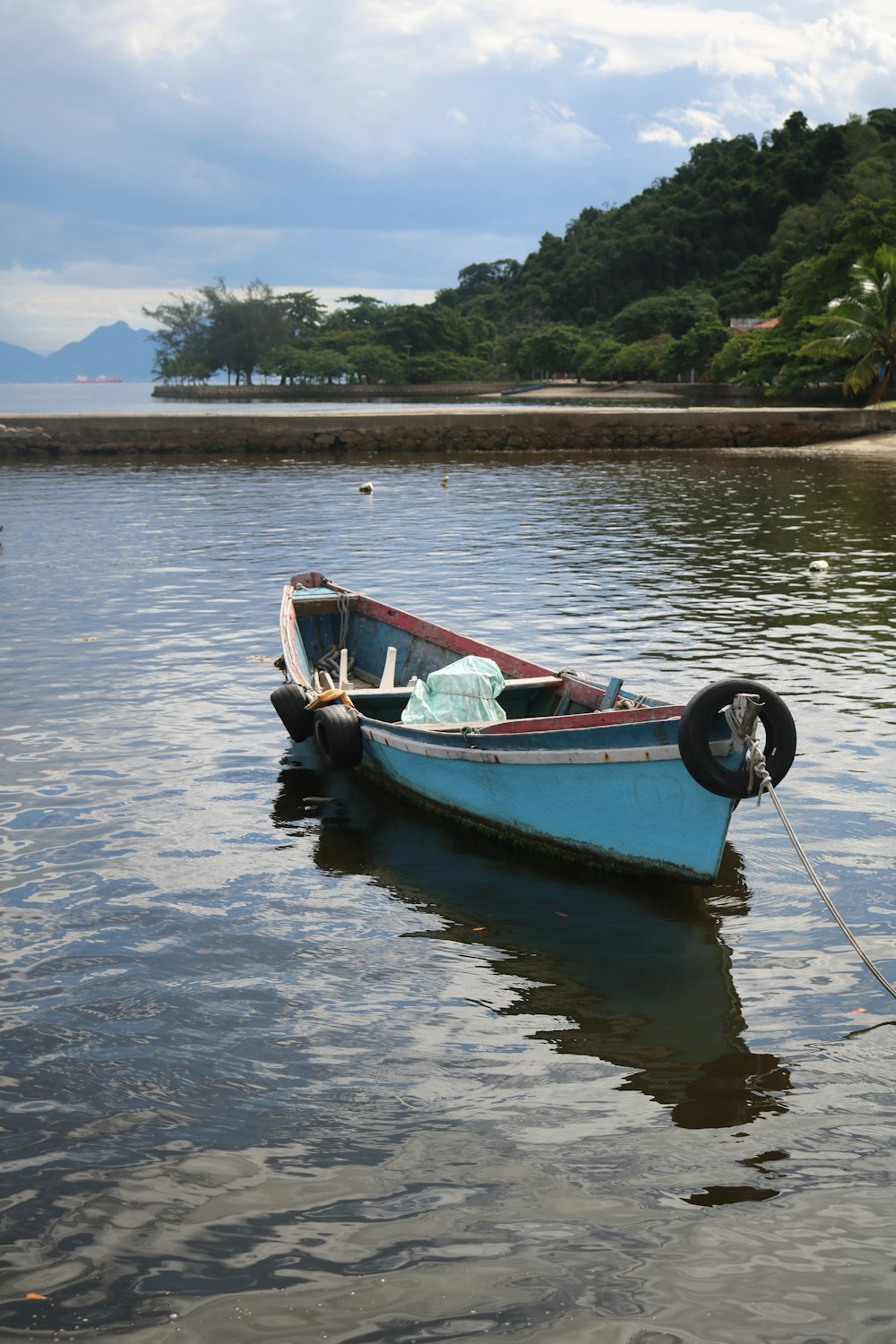 a small blue boat floating on top of a lake