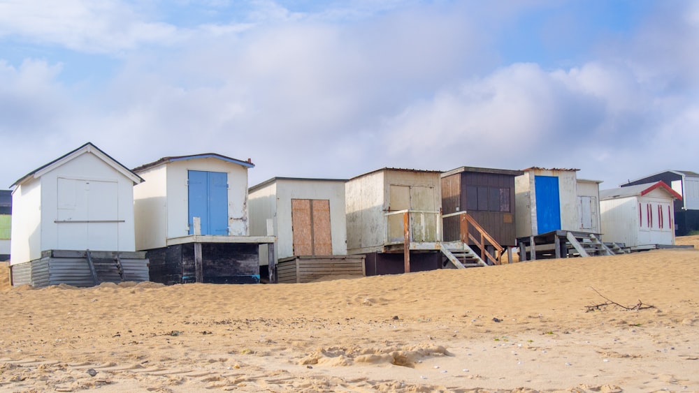 a row of beach huts sitting on top of a sandy beach