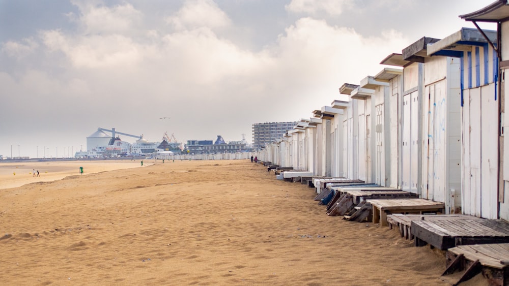 a row of beach huts sitting on top of a sandy beach