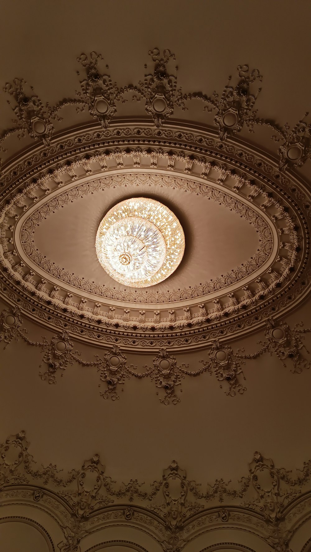 a ceiling with a circular light fixture in the middle of it