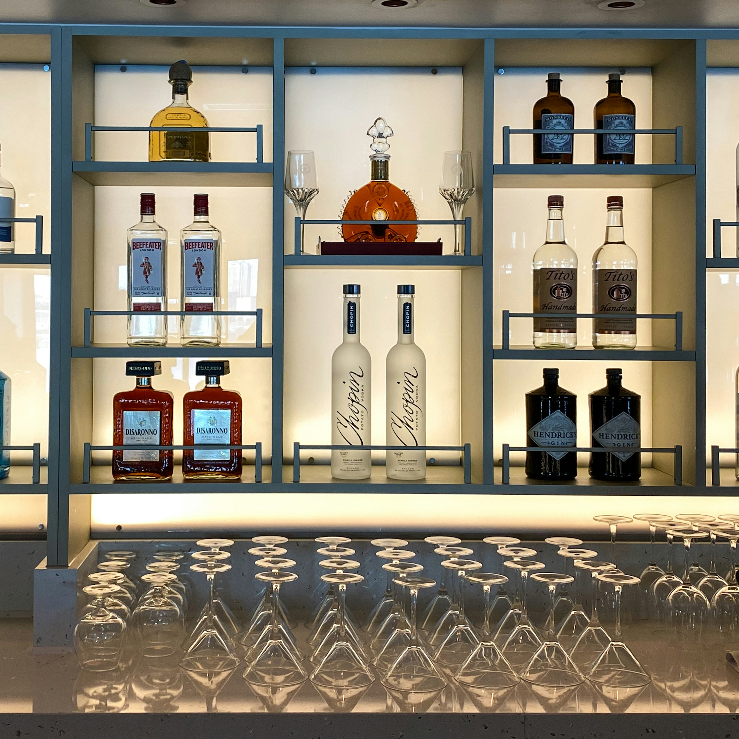 uma exposição de garrafas e copos em uma caixa de vidro