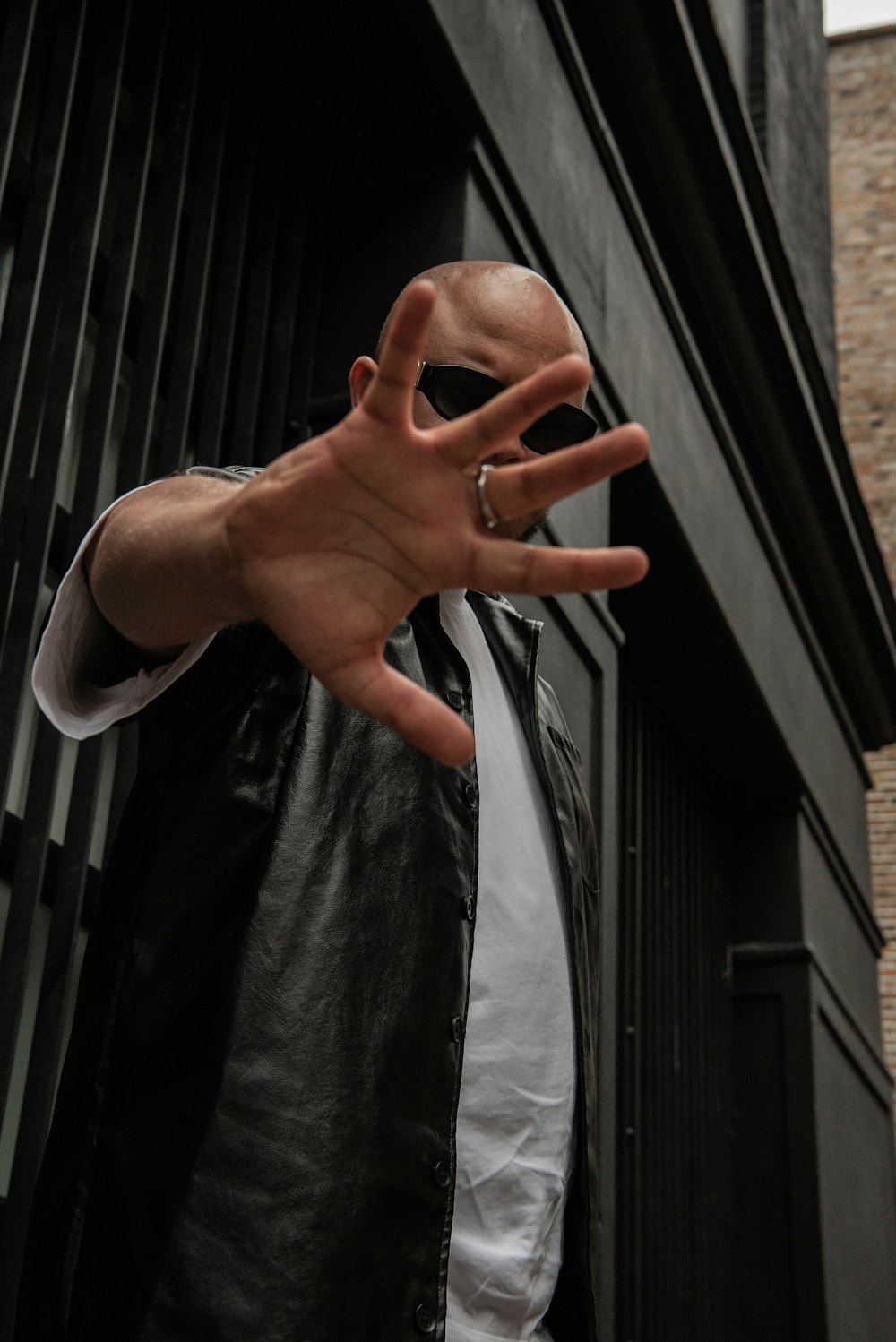 a man in a leather jacket making a hand gesture