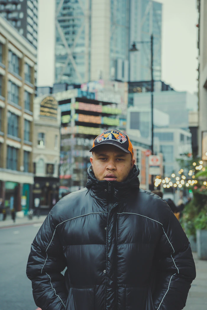 Man in a glossy black puffer jacket on a city street