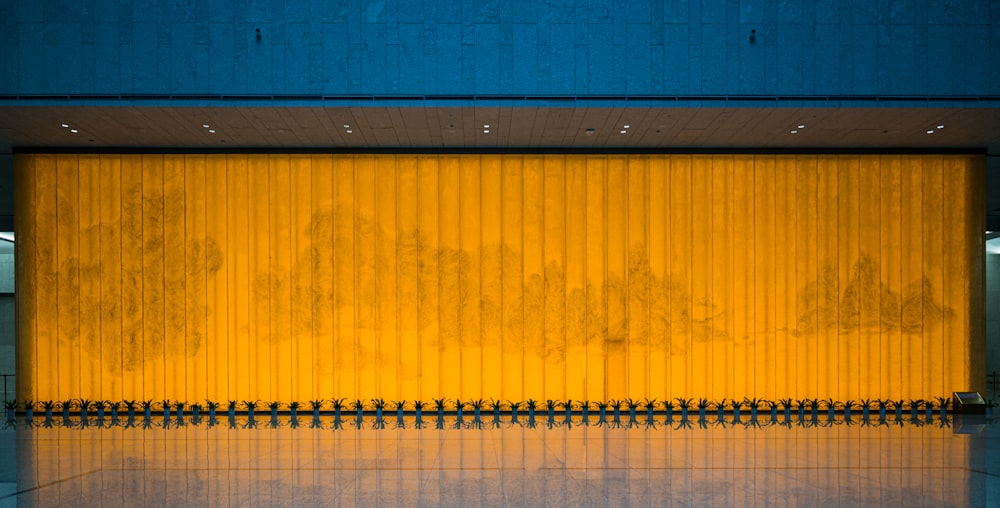 a yellow wall with a bench in front of it