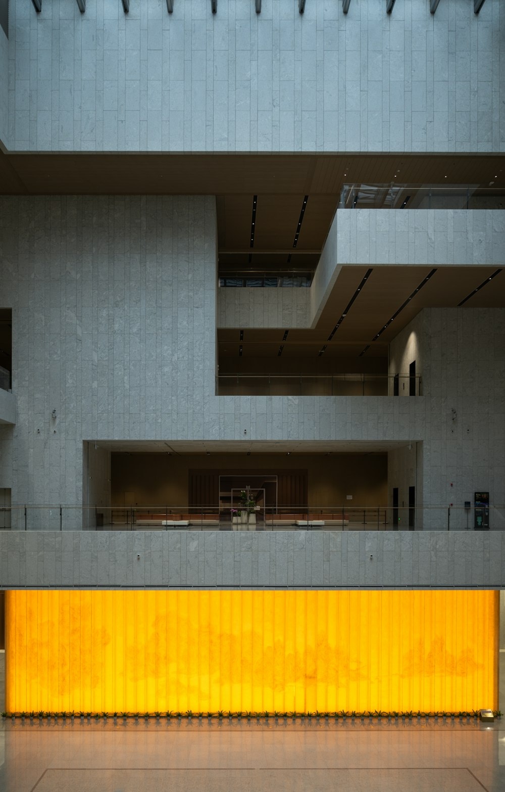 an empty building with a yellow wall in front of it
