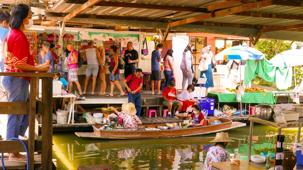 a group of people standing on a dock next to a boat