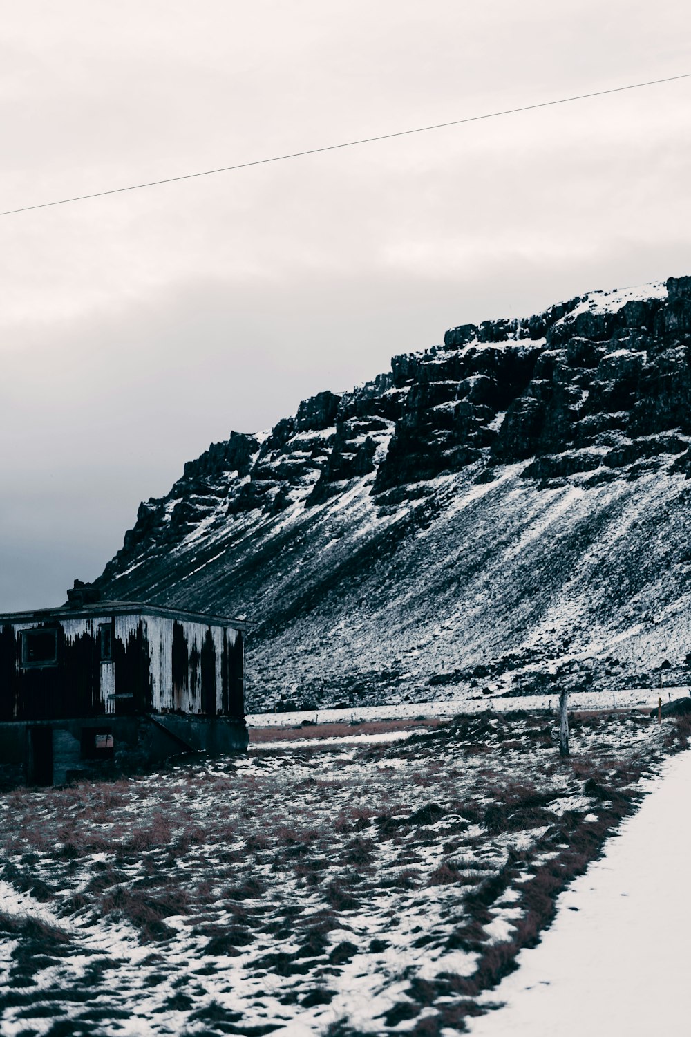 Un tren que viaja por las vías junto a una montaña cubierta de nieve