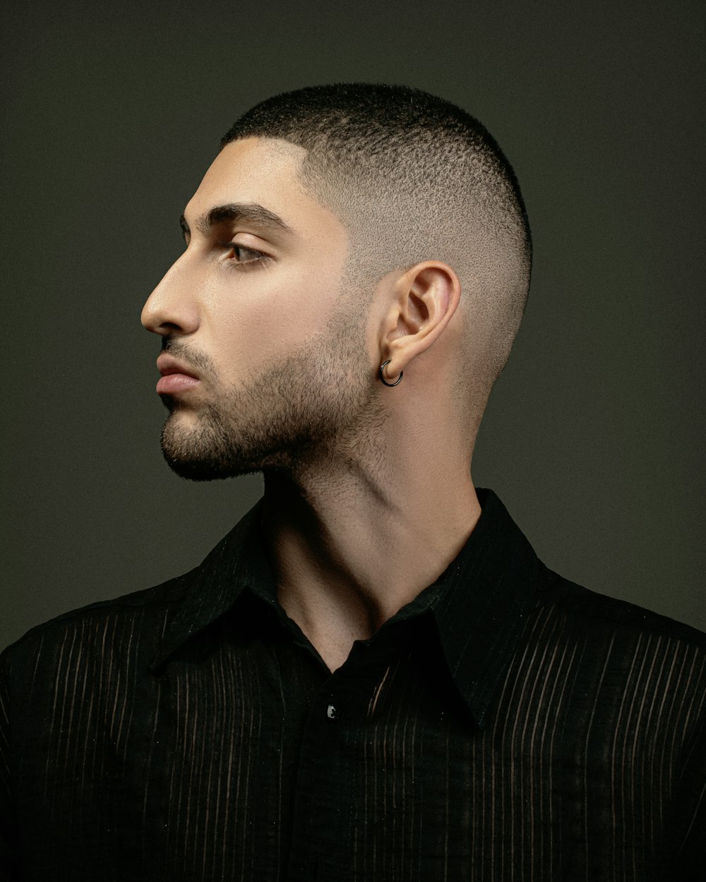 a man with a shaved head and a black shirt