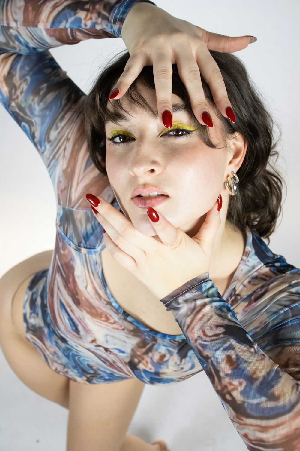 a woman with red and yellow nails posing for a picture