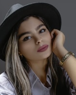 a woman wearing a black hat and a white shirt