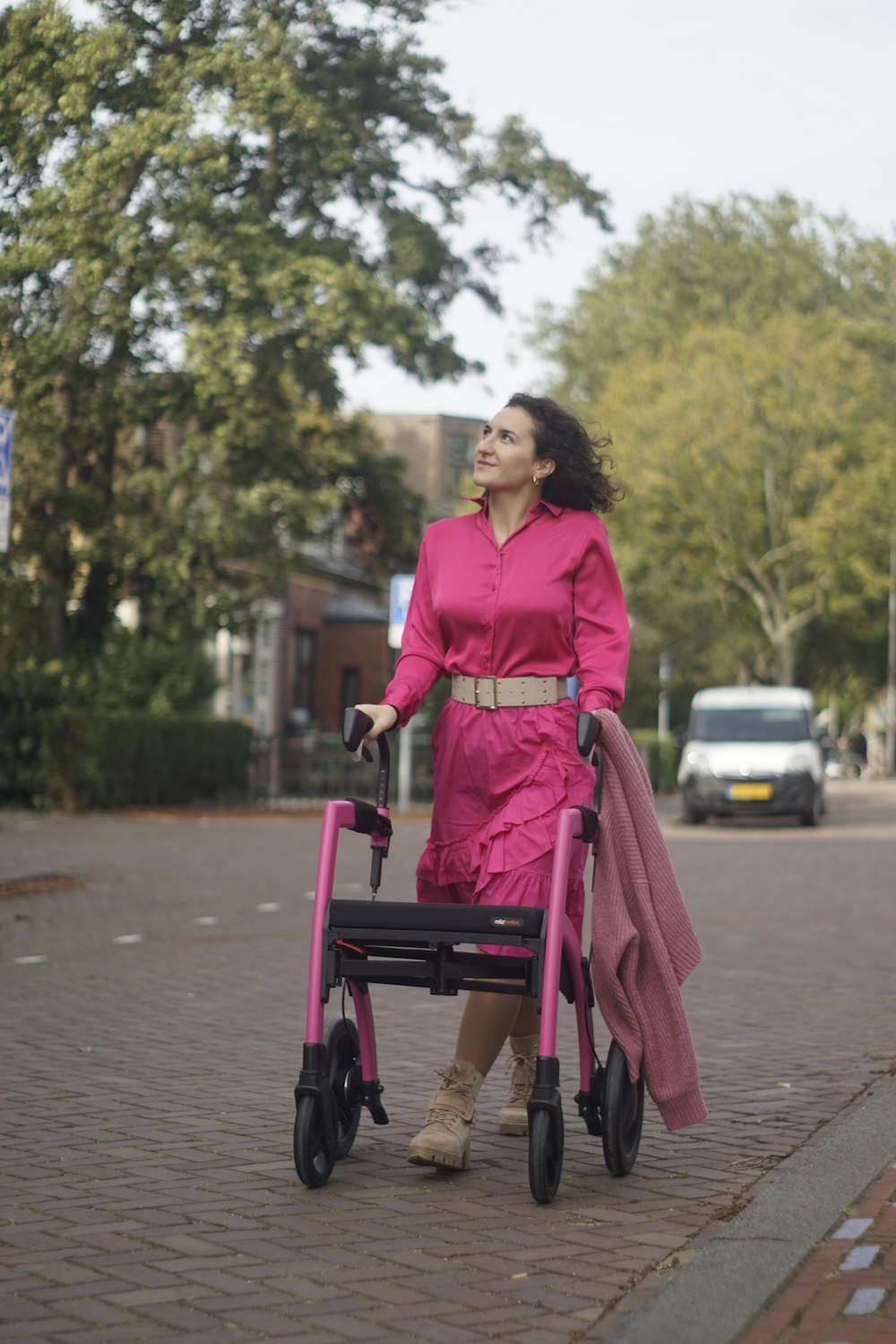 a woman in a pink dress pushing a pink walker