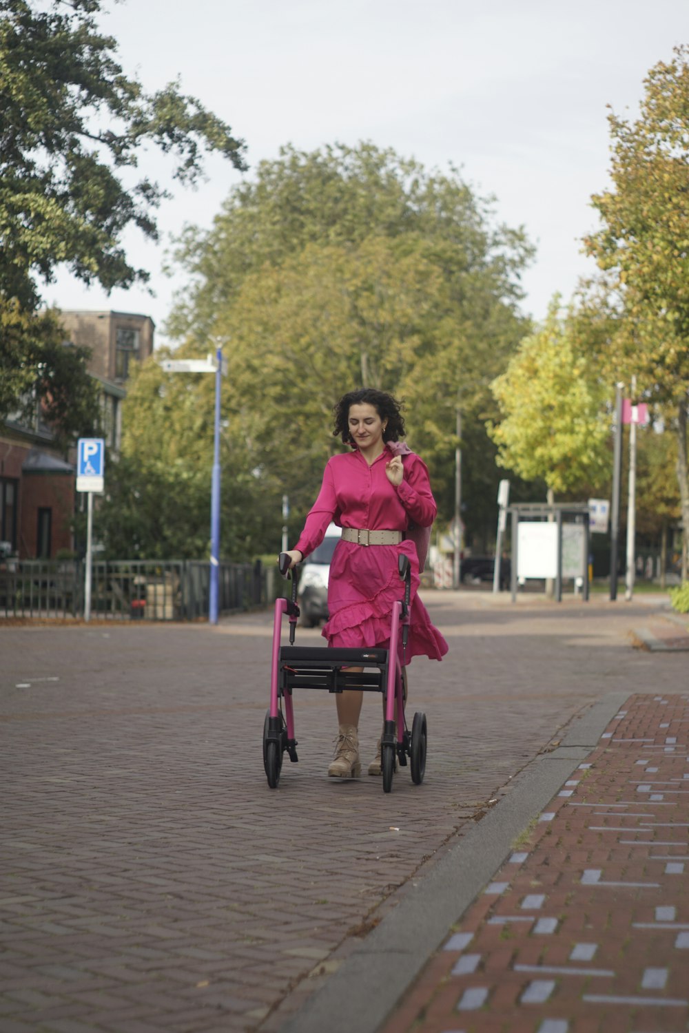 a woman in a pink dress pushing a stroller