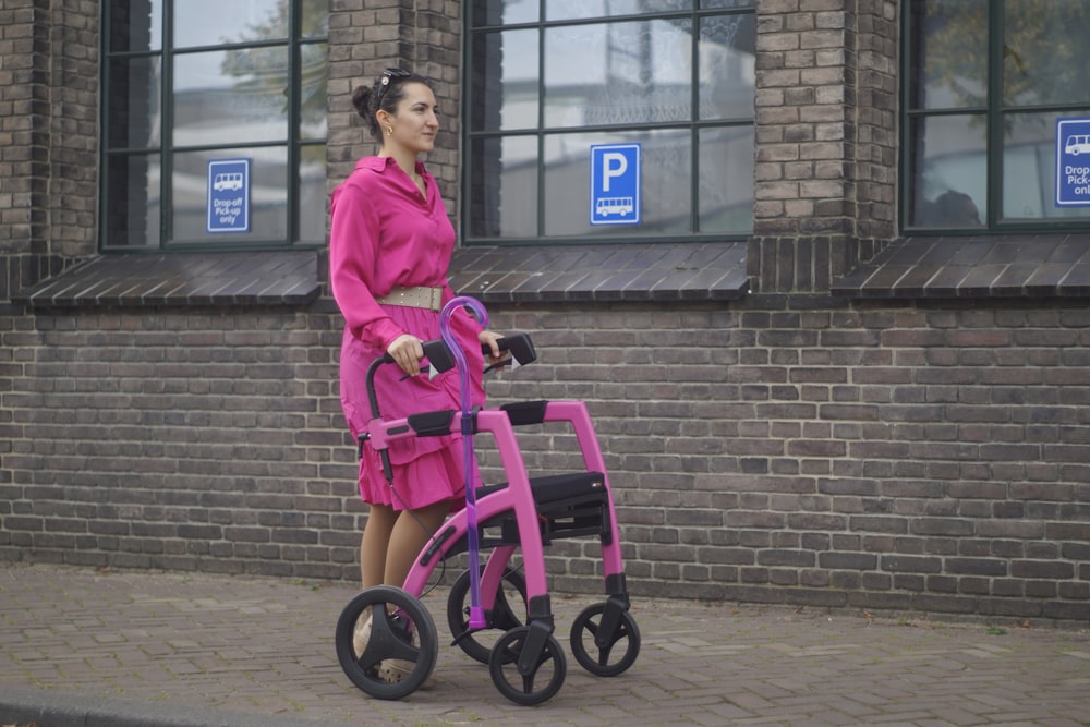 a woman in a pink dress pushing a pink walker