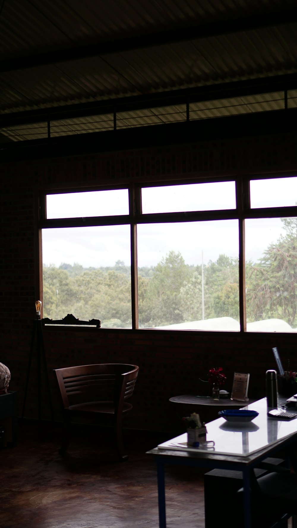 a room with a table, chairs and a large window