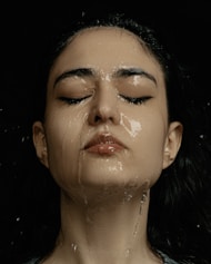 a woman with her eyes closed covered in water