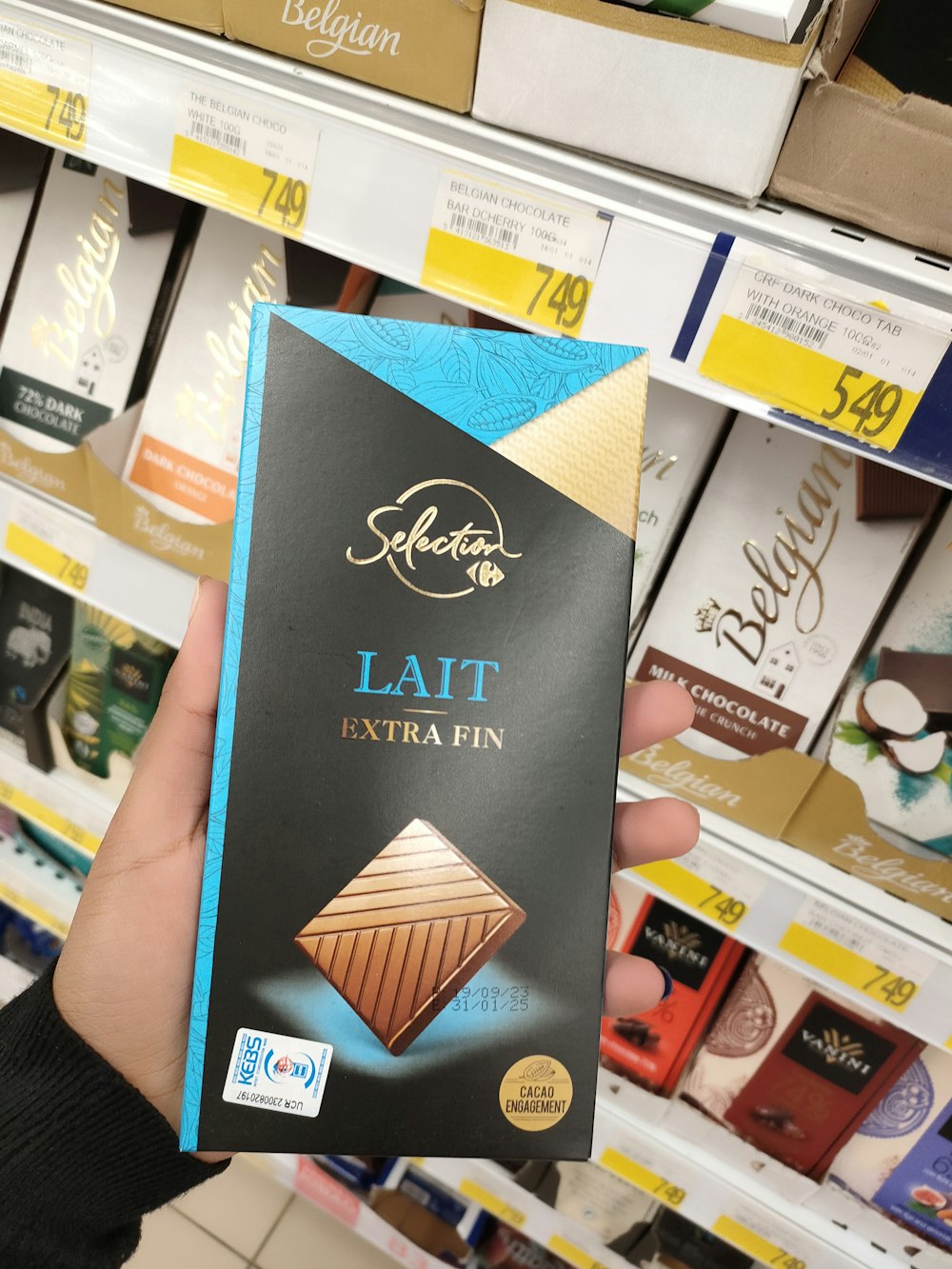 a person holding up a chocolate bar in a store