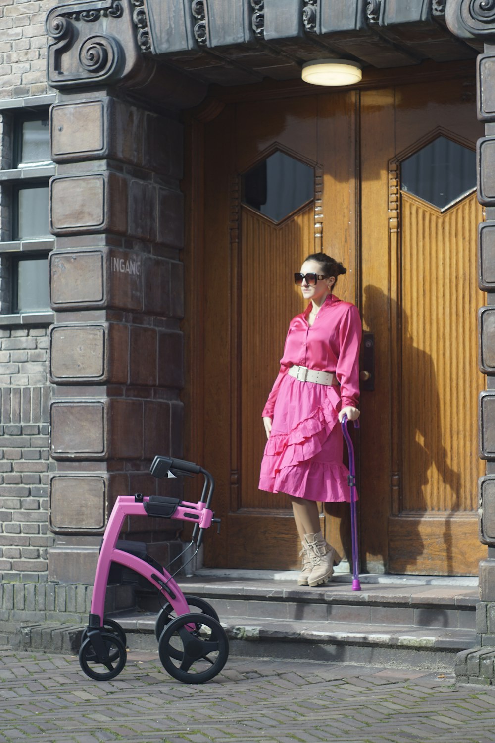 a woman in a pink dress standing in front of a door