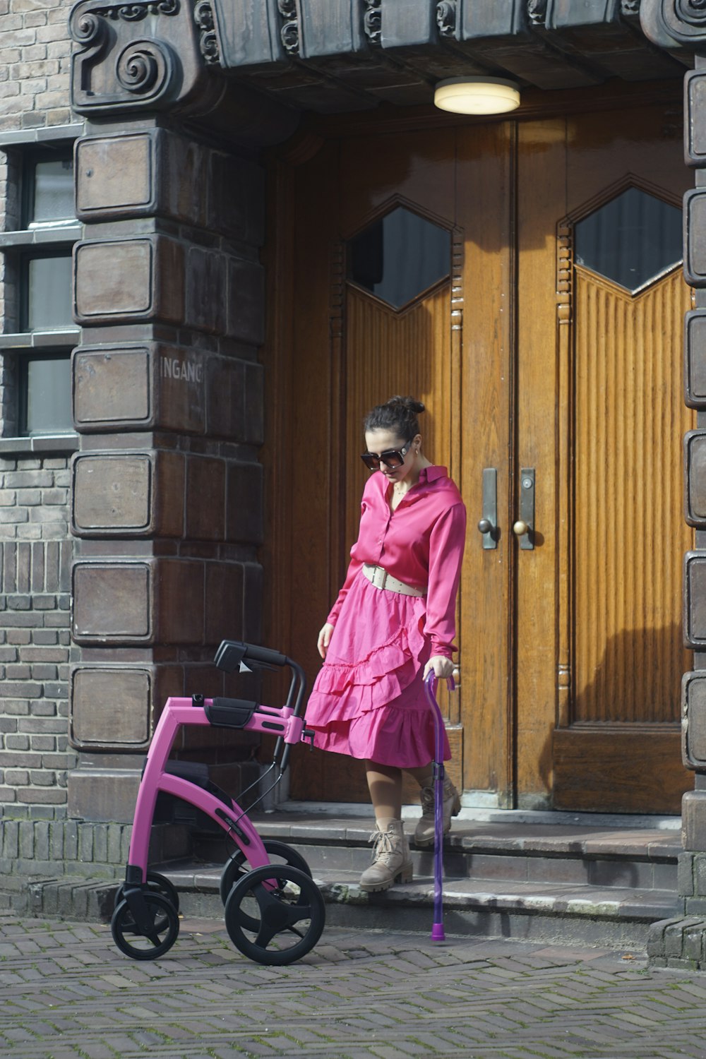 a woman in a pink dress with a pink stroller