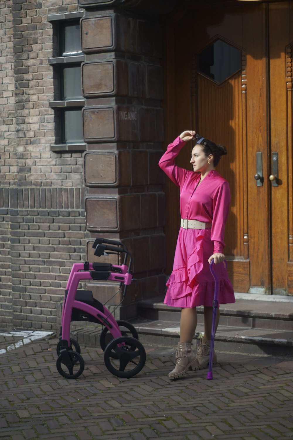 a woman in a pink dress holding a purple umbrella