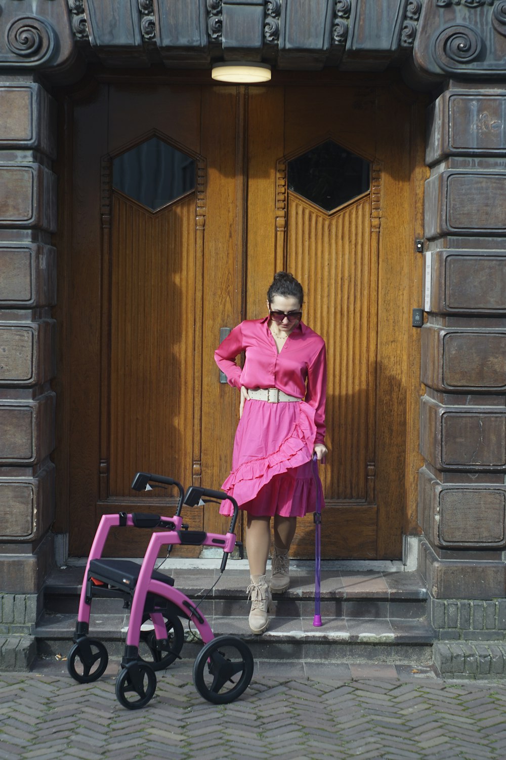 a woman in a pink dress standing in front of a door