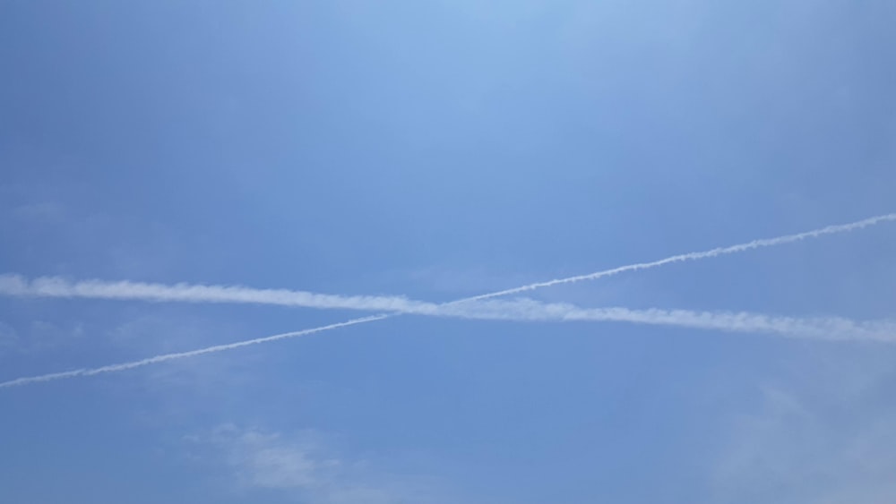 Dos aviones volando en el cielo con estelas en el cielo