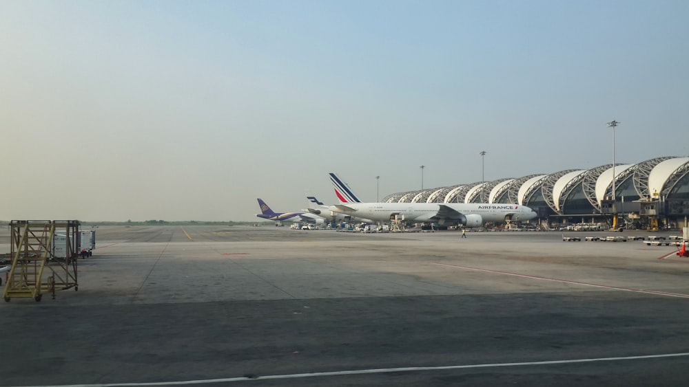 Una fila de aviones estacionados en un aeropuerto